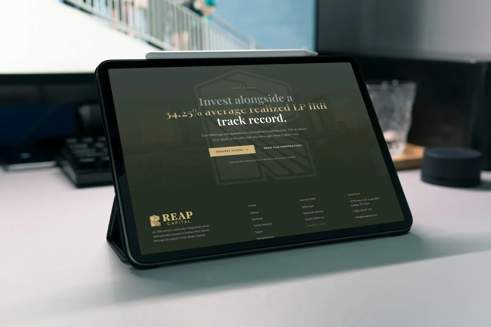 The invest section and footer on a tablet, on a desk